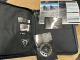 une mallette noire sur laquelle se trouvent un passeport et un livre