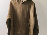 a brown hoodie hanging on a hanger against a white wall
