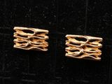 deux paires de boucles d'oreilles en or posées sur un fond de velours noir