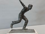 statue d'un joueur de baseball en train de lancer une balle, posée sur un socle en marbre