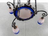 a blue glass chandelier with a mirror on it