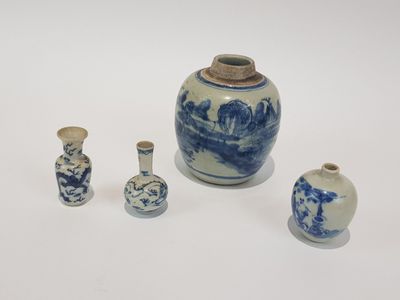 trois petits vases bleus et blancs posés sur une surface blanche