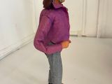 a figurine of a woman in a purple sweater and gray pants
