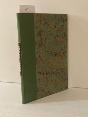 un livre à la couverture verte posé sur une table blanche