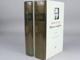two books sitting on top of each other on a white surface