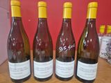 quatre bouteilles de vin sont alignées sur une table