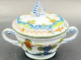a white and blue bowl with a lid sitting on a table