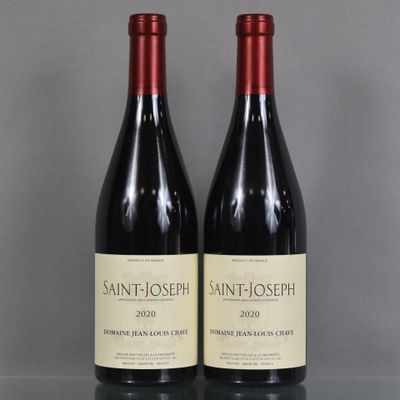two bottles of red wine sit on a table next to each other