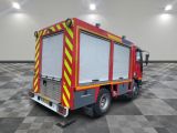 a red and yellow fire truck parked in a room