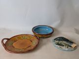 two bowls and a fish shaped dish on the table