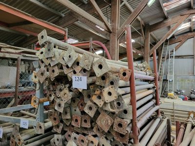 a large pile of metal pipes in a warehouse
