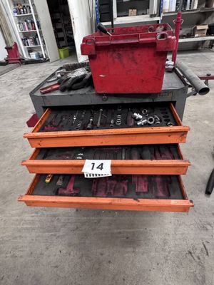 une boîte à outils rouge posée sur un coffre à outils rouge