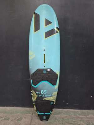 une photo d'une planche de surf appuyée contre un mur