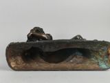 bronze sculpture of a man on a rock with a dog on his back