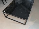 une table en verre sur laquelle est posé un livre, au milieu d'une pièce