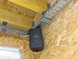 ceiling mounted air conditioner in the corner of a room with plywood flooring