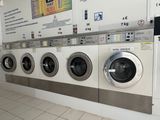 a row of washing machines lined up in a public washroom