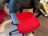 a red office chair with a black seat in a room