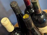 several bottles of wine sit on a wooden tray on a table