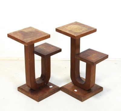 deux tabourets en bois placés l'un à côté de l'autre sur une surface blanche