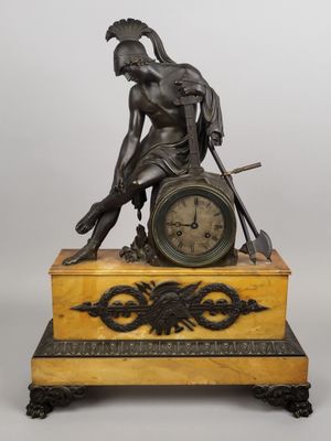 une photo représentant la statue d'un homme avec une horloge posée sur une table