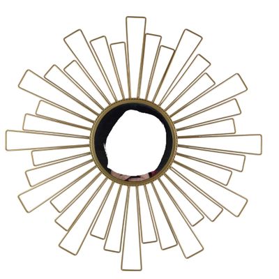 a gold sunburst on a white wall with a person in the middle
