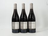 three bottles of wine sitting on top of a white table