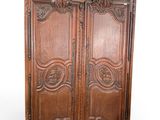 une vieille armoire en bois avec des gravures et des sculptures sur les portes