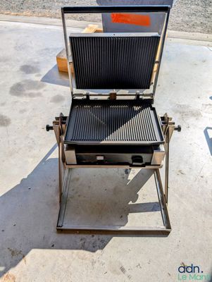 un barbecue sur lequel se trouve une grille, au milieu de la rue