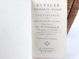 an old book sitting on top of a table next to a stack of books