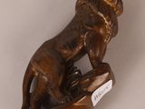 bronze figurine of a lion on a wooden base