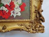painting of red and white flowers in a gold frame on a white wall
