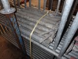 a large pile of steel pipes in a warehouse