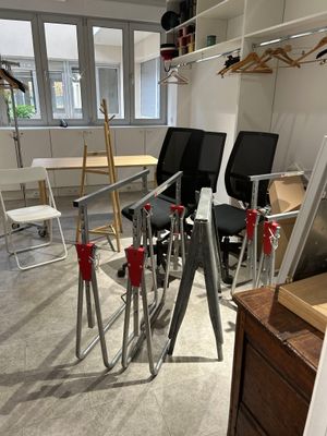 a room with a desk, chairs, and a mirror in it