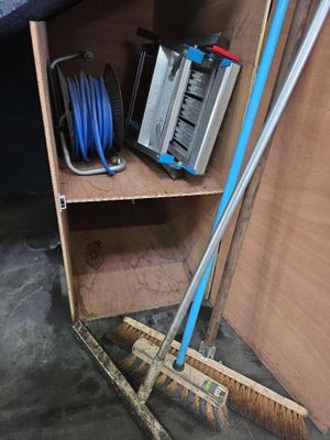 une petite étagère sur laquelle se trouvent un balai et d'autres objets