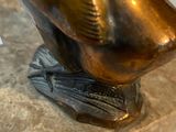 a bronze statue of a woman holding a cell phone