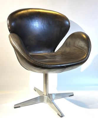 un fauteuil en cuir noir avec un piètement en métal sur fond blanc
