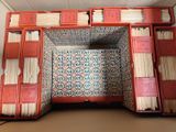a red box with books inside of it on top of a table