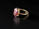 a gold ring with a pink tourmaline stone