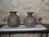 deux vases posés sur une table devant un mur de briques
