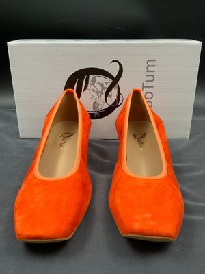 une paire de chaussures orange posée sur une boîte
