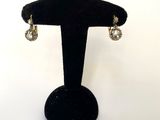 gros plan d'une paire de boucles d'oreilles sur un support noir