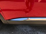 the rear end of a red car with a reflection of a person in the mirror