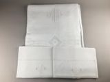 un gros plan sur un drap blanc plié, orné d'un motif