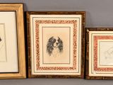 three framed drawings of dogs are on display in a gold frame