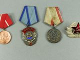 three medals and a medal on a white surface with a red star in the middle