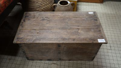 une petite boîte en bois posée par terre dans une pièce