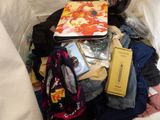 a pile of clothes and a book on a bed