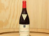 une bouteille de vin posée sur un tonneau en bois