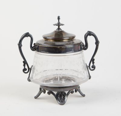 an antique silver plated teapot with a glass lid on a stand